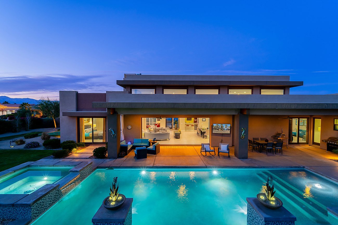 Contemporary farmhouse-style residence with pool at dusk — representational imagery